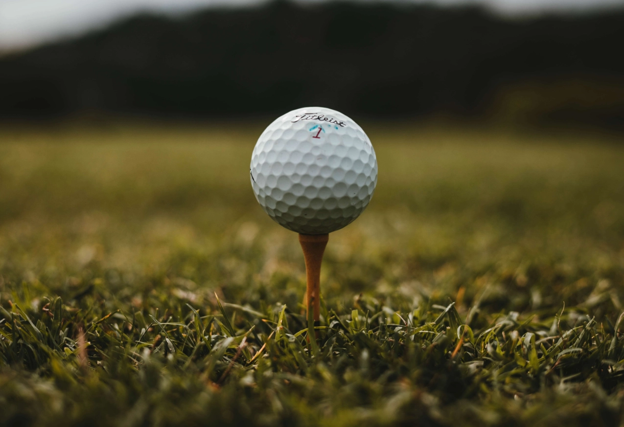 Golf ball on tee, close-up shot with blurred background